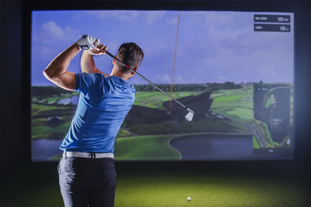 Golfer using an indoor golf simulator